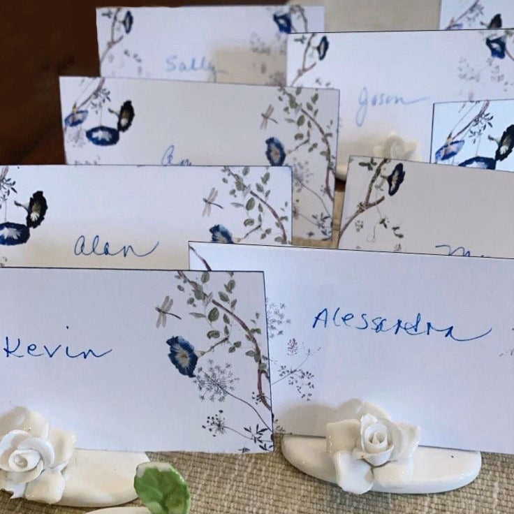 Decorative name cards with floral designs and matching name card holders tablescape. 